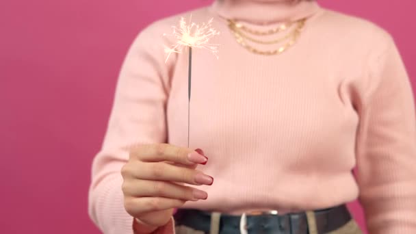 Nahaufnahme von Frauenhänden, die glitzerndes Licht im Studio vergolden — Stockvideo