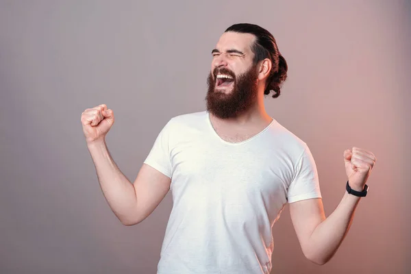 Izgatott fiatal szakállas hipszter férfi ünnepli a győzelmet — Stock Fotó