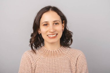 Kameraya gülümseyen kısa saçlı bir kızın portresi..