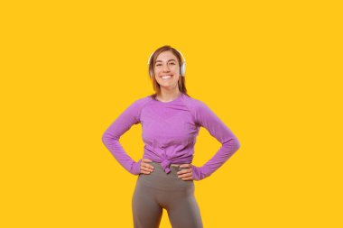 Enerjik genç kadın kulaklıklarıyla spor yapmaya hazır..