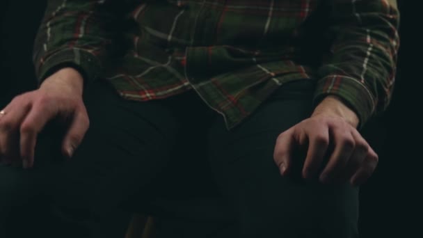 Close up filmagem de homem com tiques nervosos com as mãos sobre fundo escuro — Vídeo de Stock