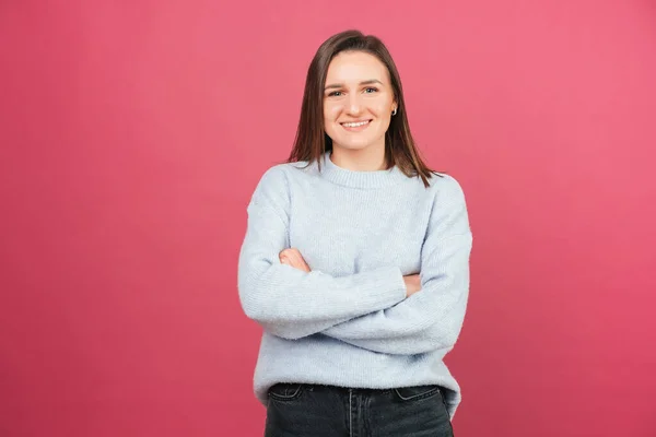 Retrato simple de una hermosa chica de pie con los brazos cruzados mientras sonríe a la cámara. — Foto de Stock