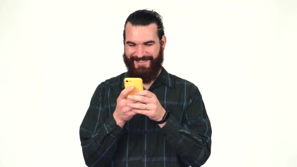Wideo uśmiechniętego mężczyzny z brodą za pomocą smartfona na białym tle — Wideo stockowe
