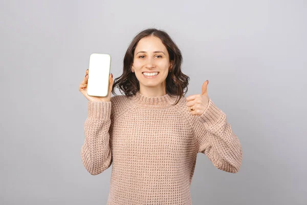 Jonge glimlachende vrouw toont blanco scherm en duim omhoog. — Stockfoto