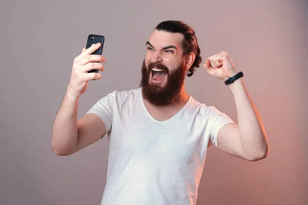 Зміст Бородатого Чоловіка Кричить Голосно Дивлячись Екран Телефону Роблячи Жест — стокове фото
