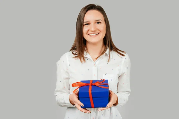 Positive Junge Frau Hält Eine Blaue Geschenkbox Der Hand Und — Stockfoto