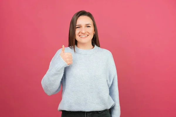 Encantadora Jovem Sorridente Está Segurando Polegar Sobre Fundo Rosa Estúdio — Fotografia de Stock