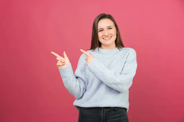 Jovem Sorrindo Mulher Está Apontando Para Lado Com Ambos Dedos — Fotografia de Stock