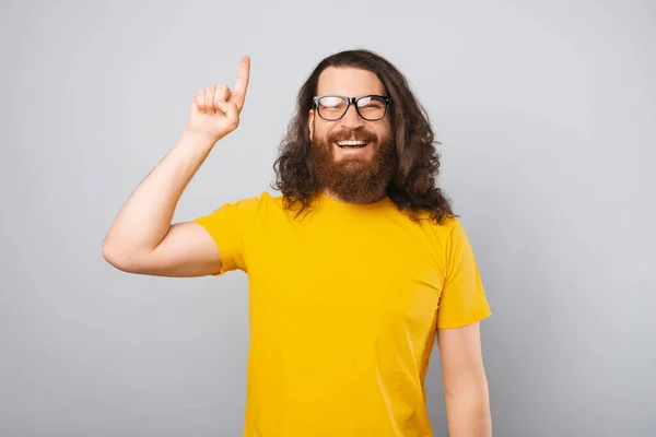 Усміхнений Бородатий Чоловік Довгим Волоссям Вказує Індексний Палець Студійний Знімок — стокове фото