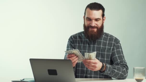 Video de un joven alegre contando dinero cerca de la oficina de escritorio — Vídeos de Stock