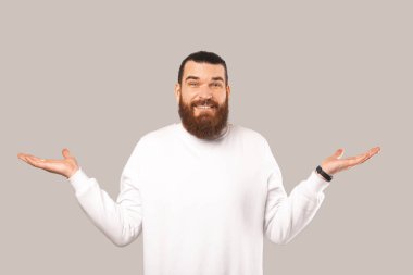 Beyaz giyinmiş belirsiz sakallı bir adamın portresi gri arkaplanı silkeliyor..