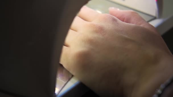 Közelkép felvétel a női kéz száradó friss körmök UV — Stock videók