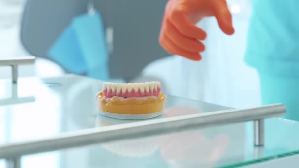Footage dokter gigi membawa gigi palsu dari meja di klinik — Stok Video