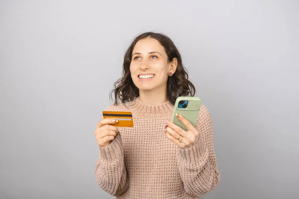 Jeune Femme Souriante Tient Une Carte Crédit Téléphone Dans Studio — Photo