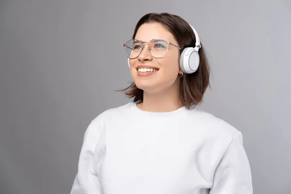 Dreaming Smiling Girl Wearing Headphones Enjoys Music While Looking Studio — Stock Photo, Image