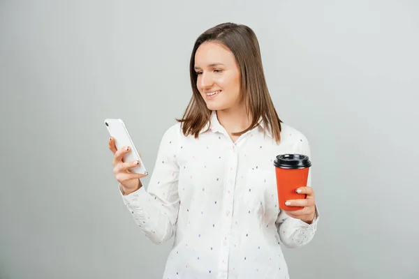 Giovane Donna Sorridente Guardando Telefono Possesso Andare Tazza Caffè Studio — Foto Stock