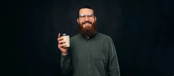 Panorama foto van een bebaarde hipster man genieten van zijn kopje koffie te gaan. — Stockfoto