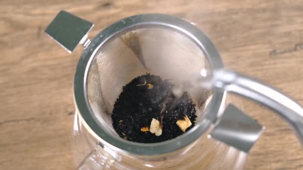 お茶のポットにお湯を注ぎ、紅茶を準備するビデオを閉じます — ストック動画