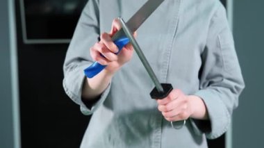 Kadın şefin mutfak bıçağını keskinleştirdiği görüntüleri kapat.