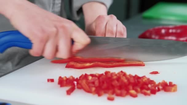 Zamknij boczny film szefa kuchni cięcia i siekania czerwonej papryki na desce tnącej — Wideo stockowe
