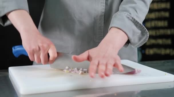 Close up footage of female chef chopping onion on cutting board with sharp knife — Stock Video