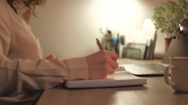 Ofis masasında mesai saatlerine kadar planlama yapan kadının videosunu kapat.