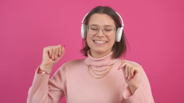 Footage of young woman wearing headphones and dancing while listening music – Stock-video