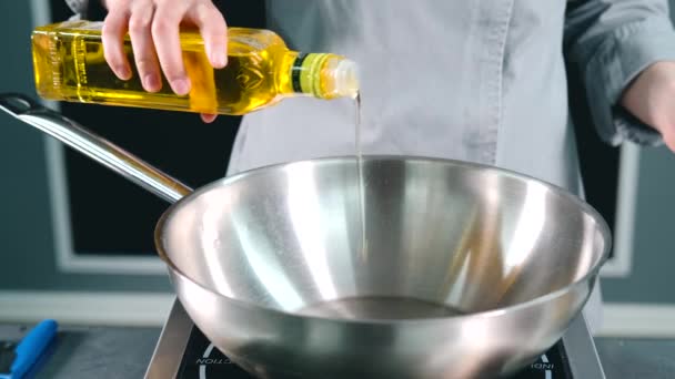 Slow motion video av Chef hälla olivolja i stekpanna — Stockvideo