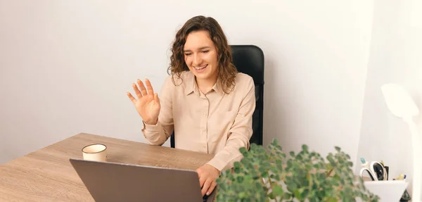 Photo of young cheerful woman having a video conference and saluting colleague. — Zdjęcie stockowe