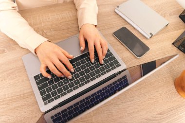 Close up photo of woman typing on laptop from above.