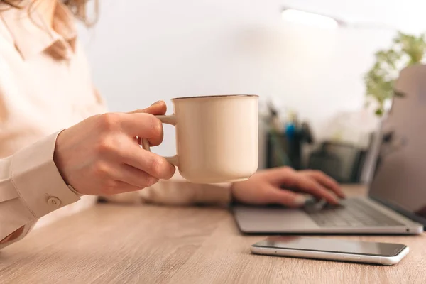 Close up photo of woman hand holding a ceramic cup of coffee in office. — Stockfoto