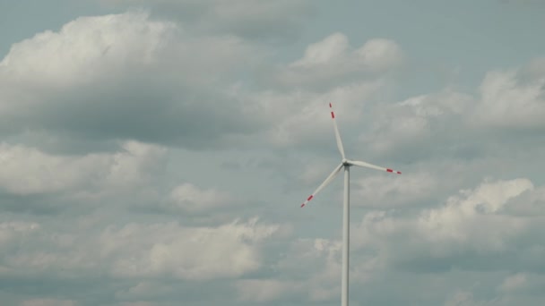 Close up footage of wind turbine for alternative energy in slow motion over beautiful cloudy sky — Video