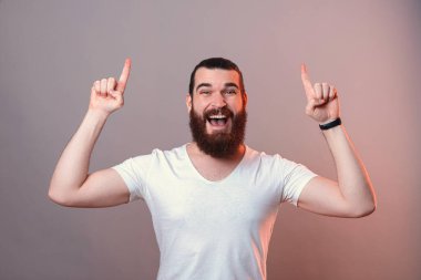 Genç mutlu sakallı adam iki eliyle fotokopi odasına doğru bakıyor..