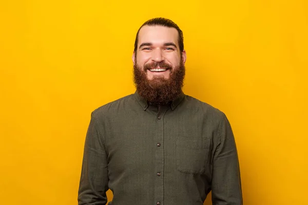 Retrato de cerca de un guapo joven barbudo sonriendo a la cámara. —  Fotos de Stock