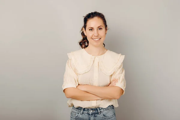 Joven mujer sonriente guapo confiado está de pie con los brazos cruzados. — Foto de Stock