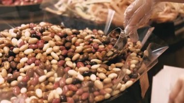 Bir kadının çikolataya kağıt poşet badem koyduğu, kahve için lezzetli bir tatlı koyduğu görüntüleri kapat..