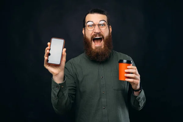 Jovem Espantado Chocado Com Barba Mostrando Tela Smartphone Uivo Xícara — Fotografia de Stock