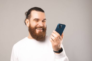 Genç sakallı adamın, hoparlörden akıllı bir şekilde konuşan fotoğrafını çek..