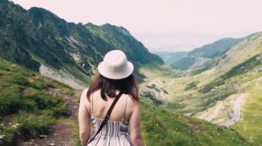 Transfagarasan yolunda yürüyen genç bir kadının görüntüsü. Yaz boyunca güzel bir yol..