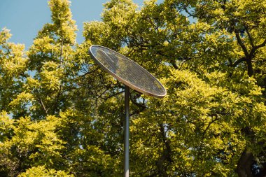 Bazı ağaçların yakınındaki güneş bataryasının yakın plan fotoğrafı.