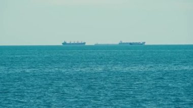 Footage of some ships floats on ocean or sea at horizon.
