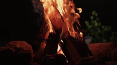 Gece vakti kamp ateşi ve alevler içinde yanan odunların videosunu kapat..
