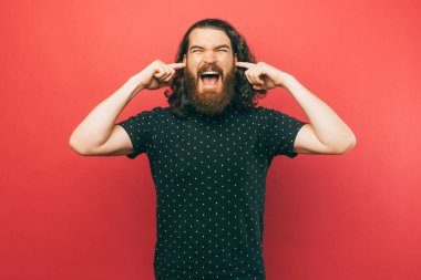 A photo of an angry man being disturbed by noise screaming at the camera 