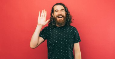 A picture of a young man waving at the camera