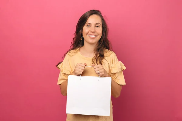 Photo Woman Holding Shopping Bag While Smiling Camera — ストック写真