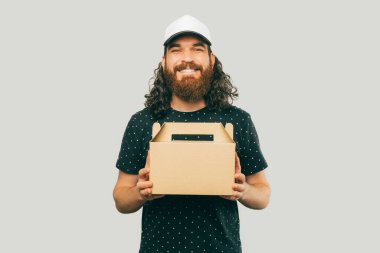 A photo of a delivery guy ready to deliver the food while he is smiling at the camera