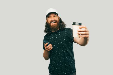 A delivery man is happily offering you a cup of coffee completing his dellvery