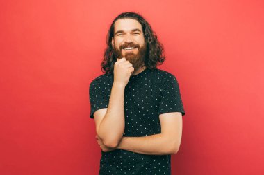 A picture of a young bearded man looking an smiling at the camera