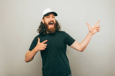 A photo of a bearded man pointing excited at a free space