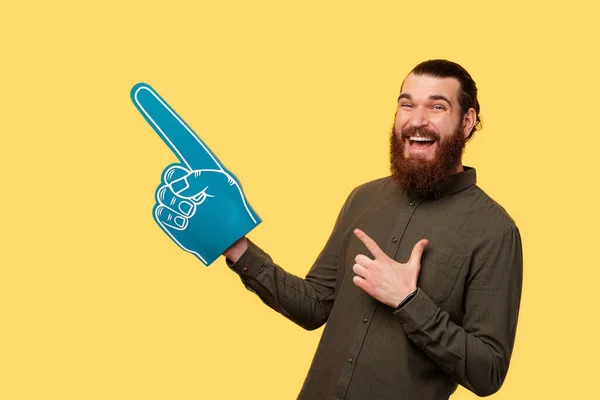 Photo Man Holding His Fan Glove Smiling Pointing Free Space — Stockfoto